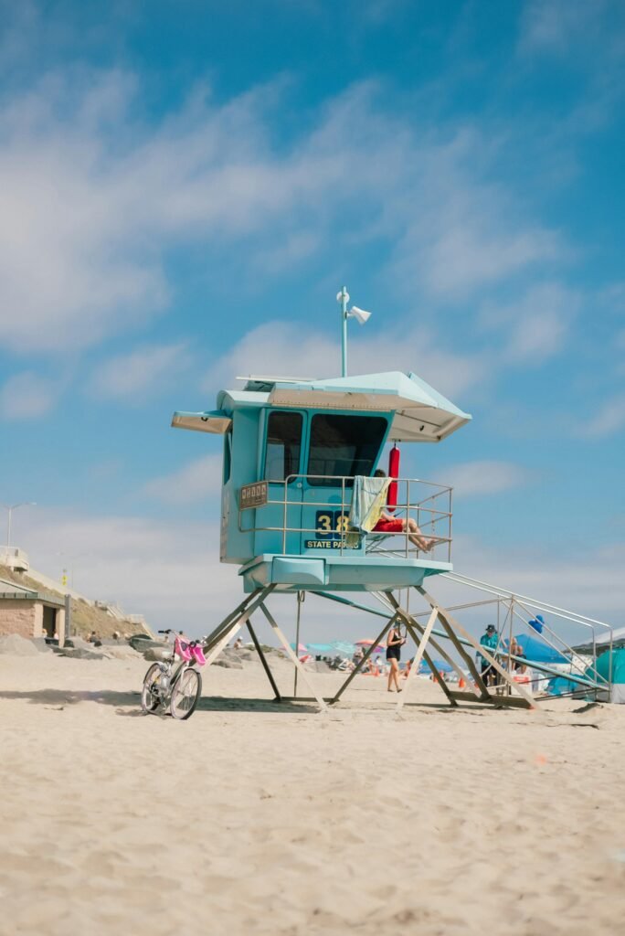 Vibrant beach scene with a lifeguard hut and a clear blue sky.